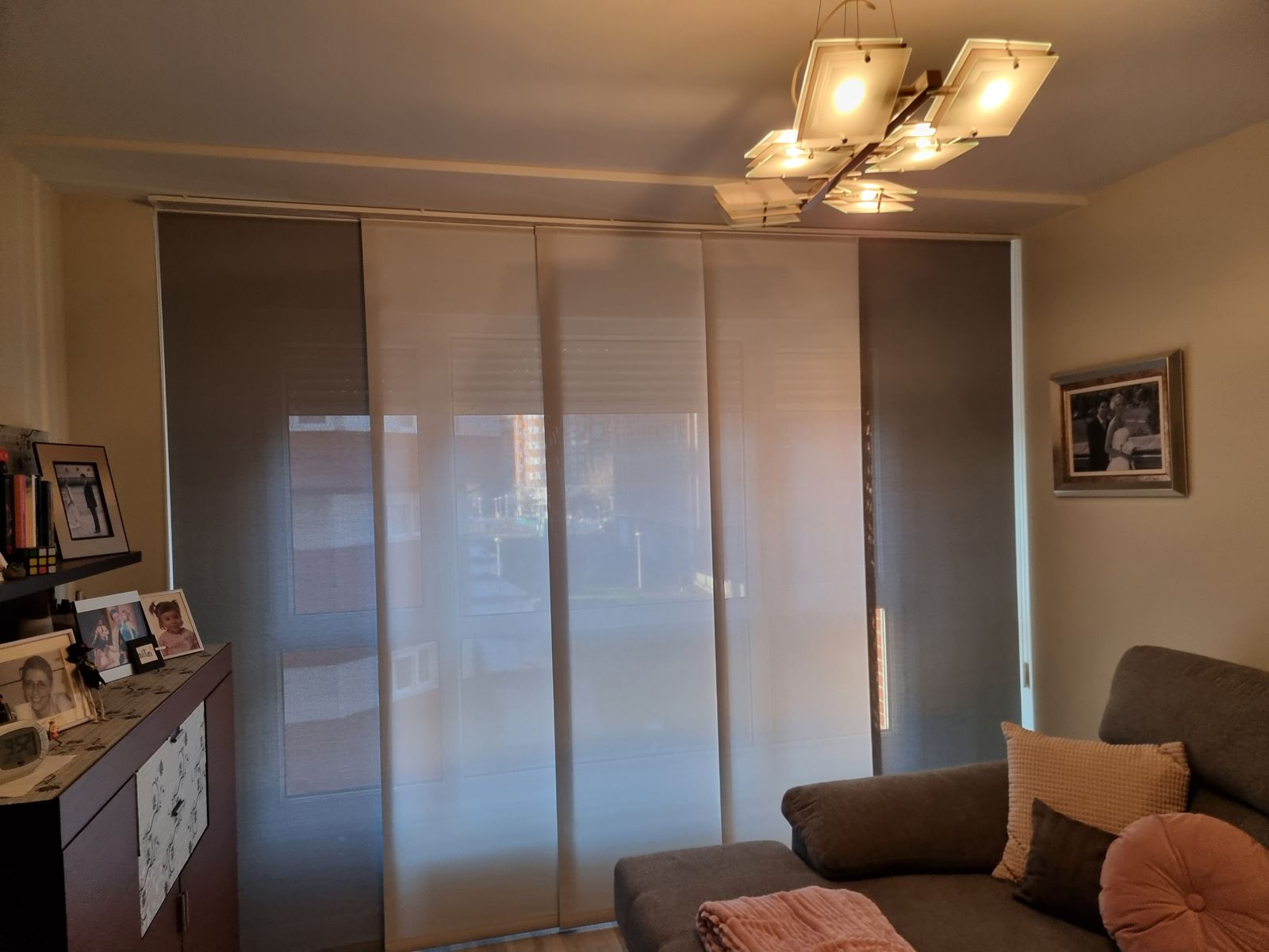 Salón con paneles japoneses deslizantes en tonos gris y blanco